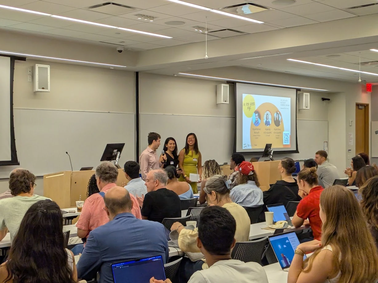 Humanity in the Room event, audience in a lecture hall with AI for Good NYC presentation on screen